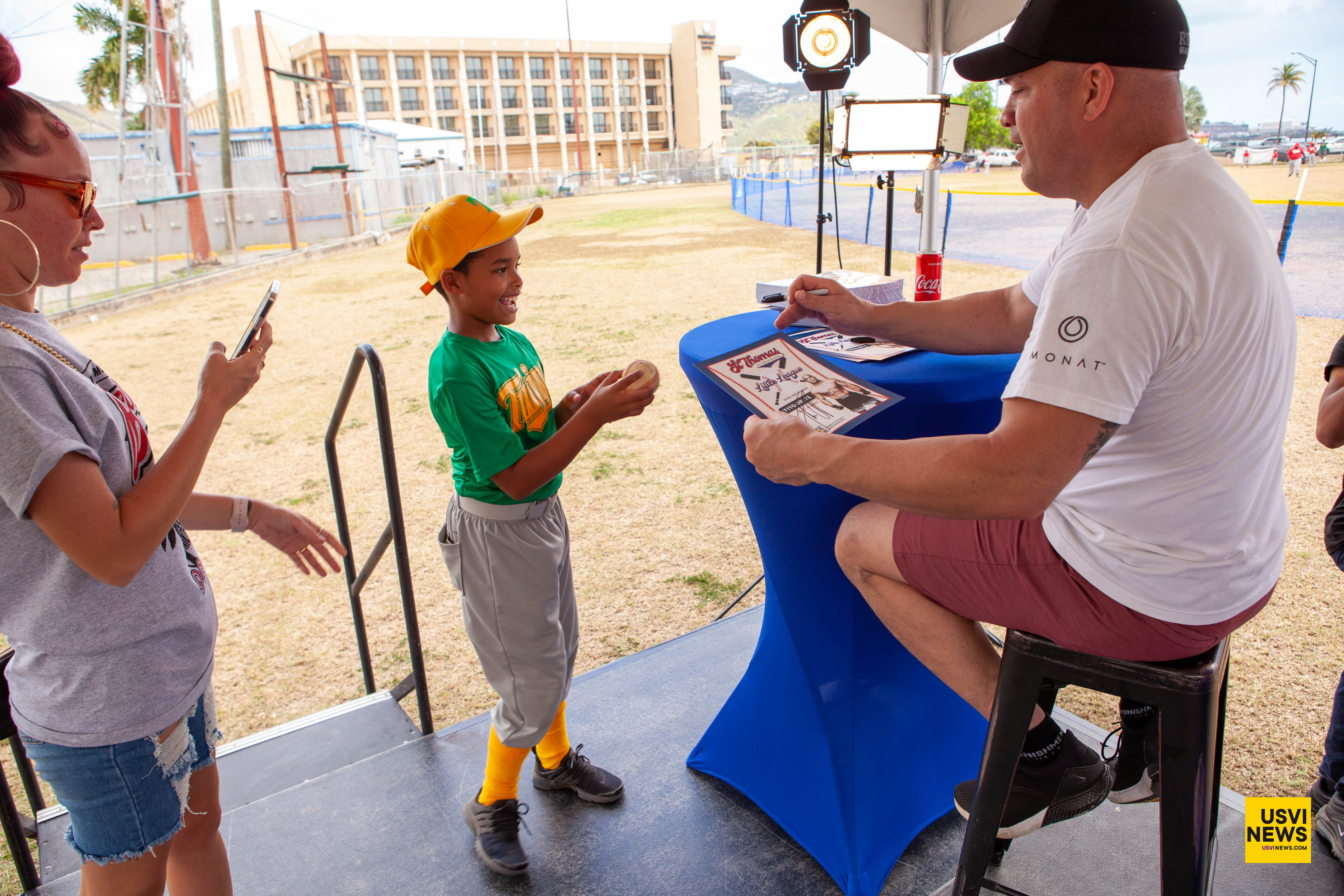 Tito Ortiz hands a signed item to a St. Thomas Little League player at Griffith Ballpark.
