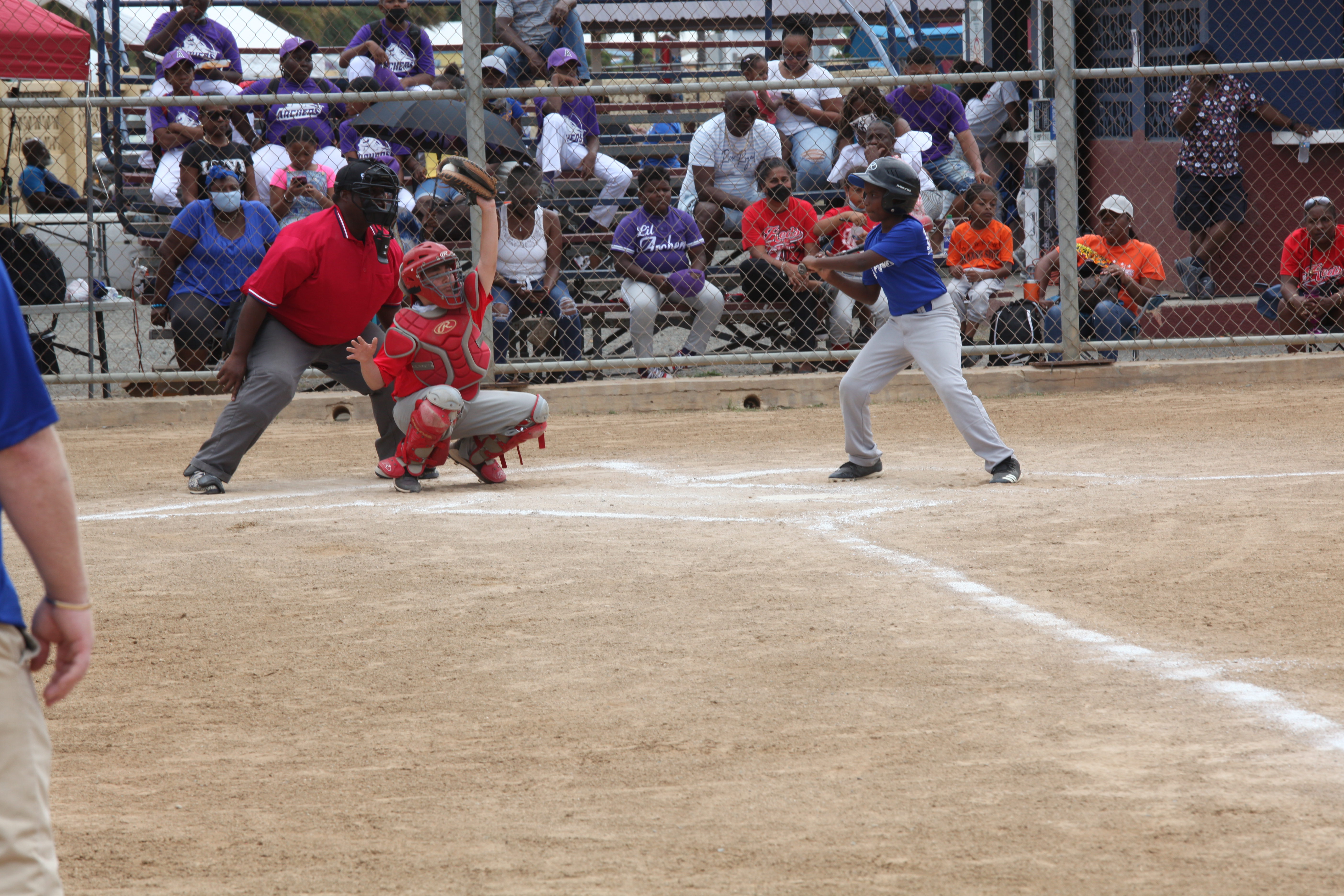 A Little League batter swings during opening day action at Griffith Ballpark in St. Thomas.