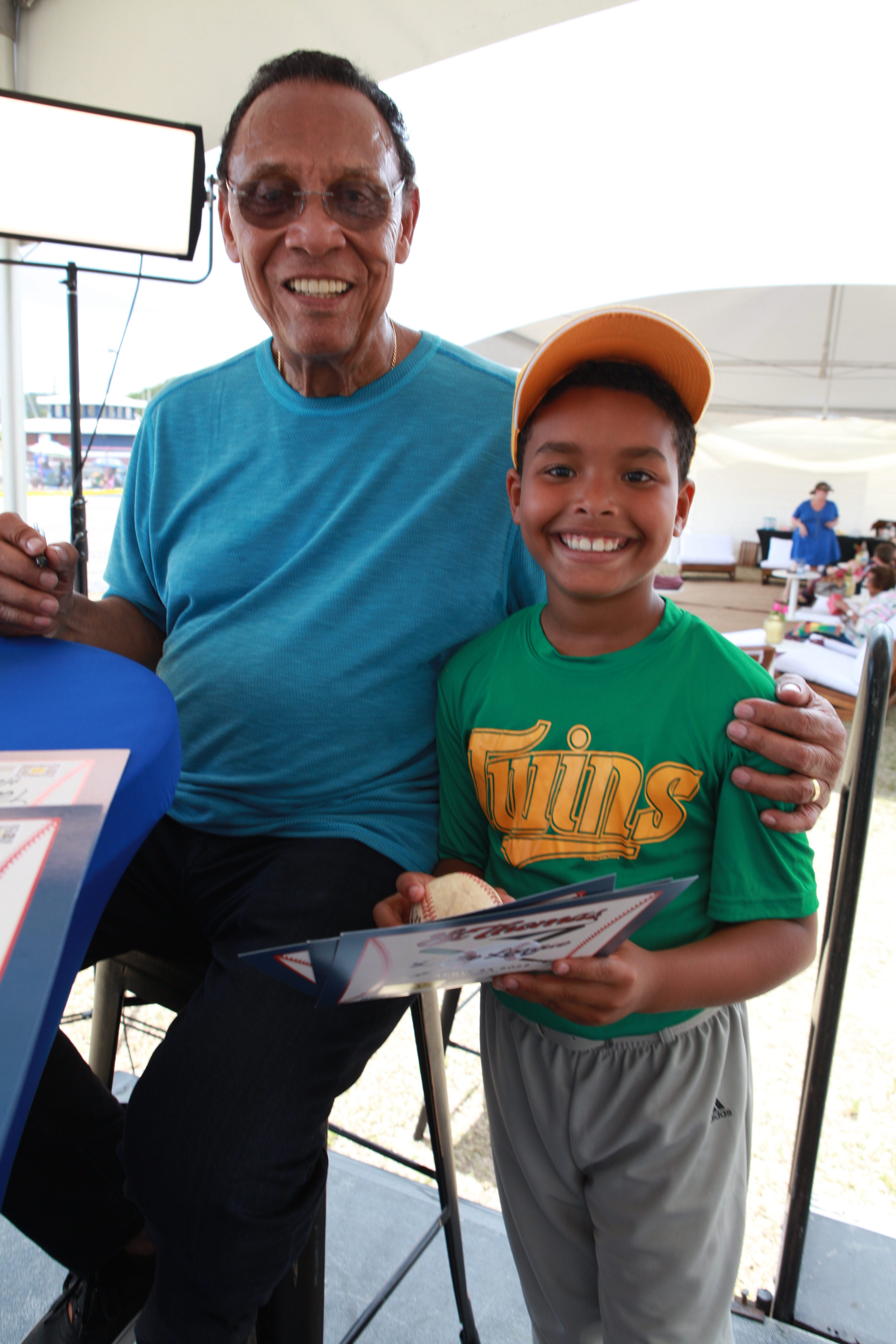 Tony Perez poses with a young Little League player holding a signed certificate at Griffith Ballpark.