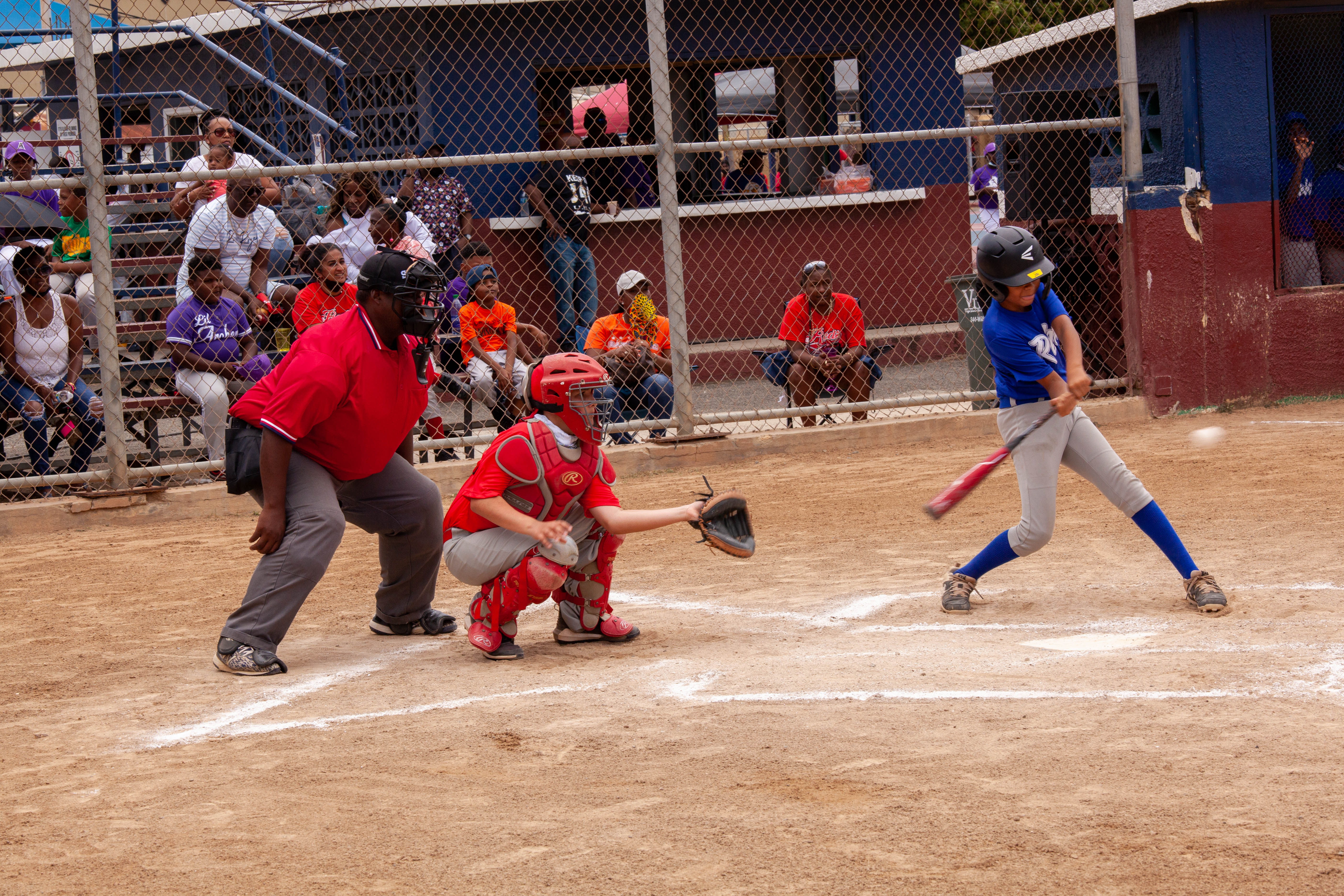 Batter swings as catcher and umpire watch at home plate.