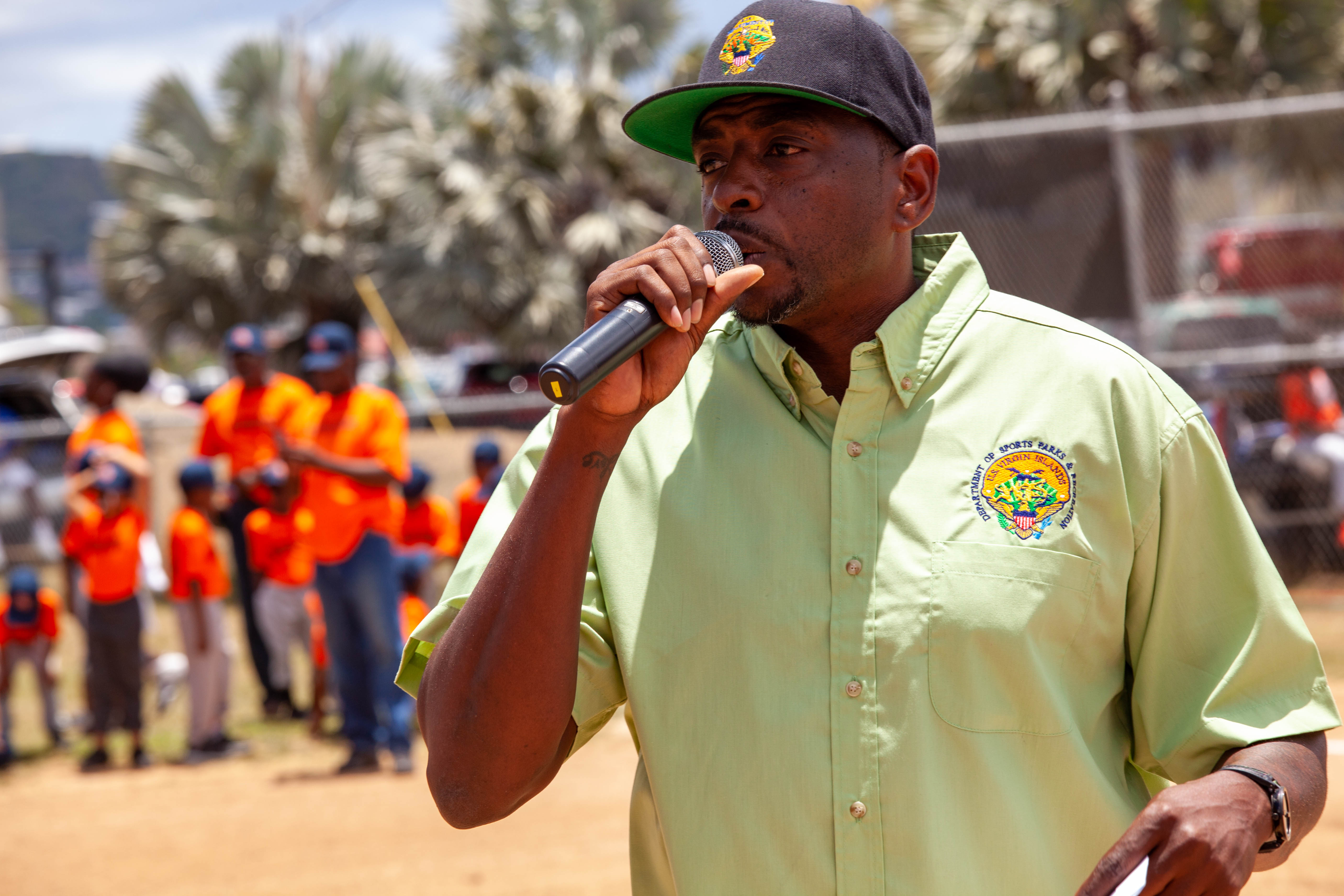 Calvert White speaks into a microphone near youth players.