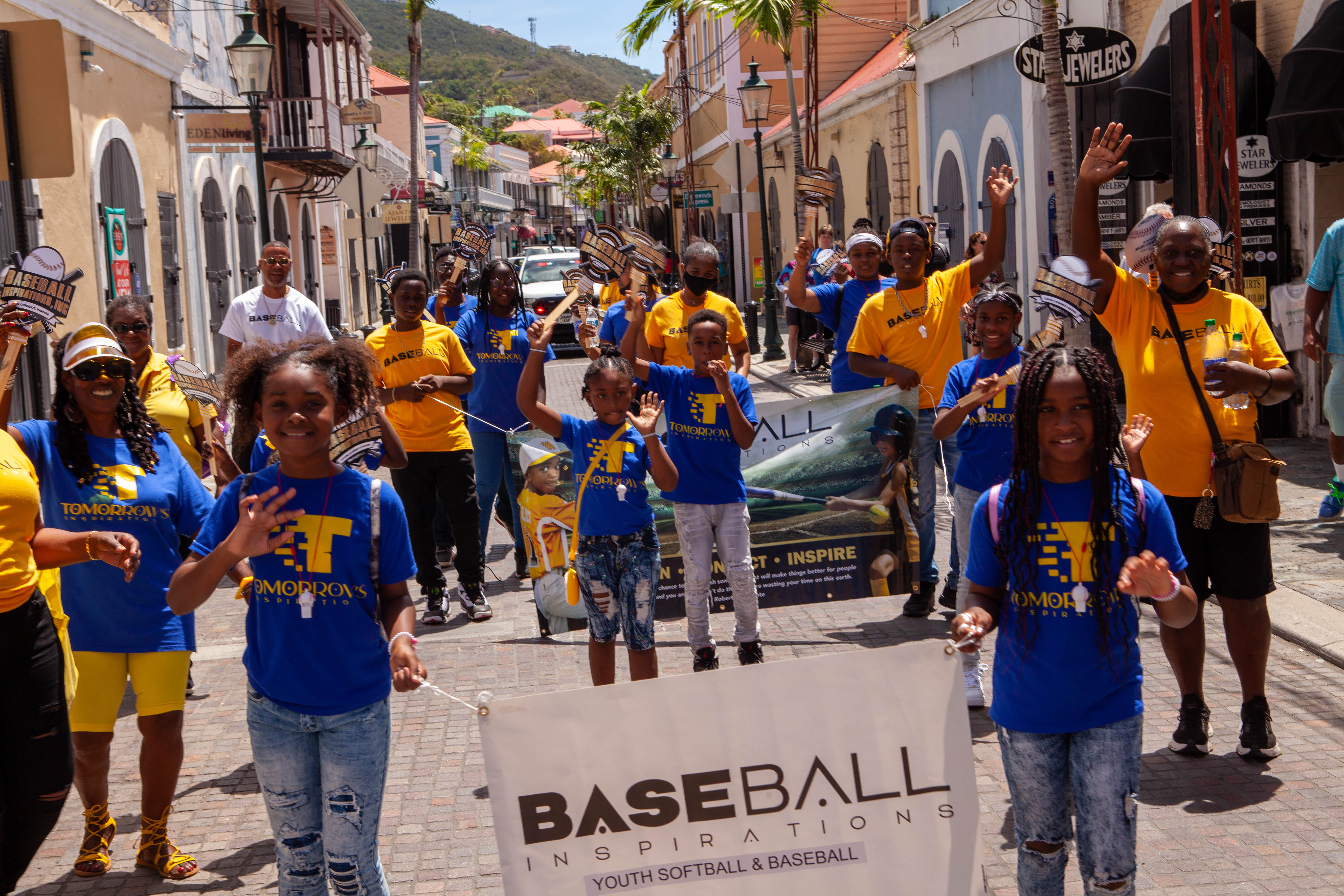 Youth group carries baseball banner during street parade.