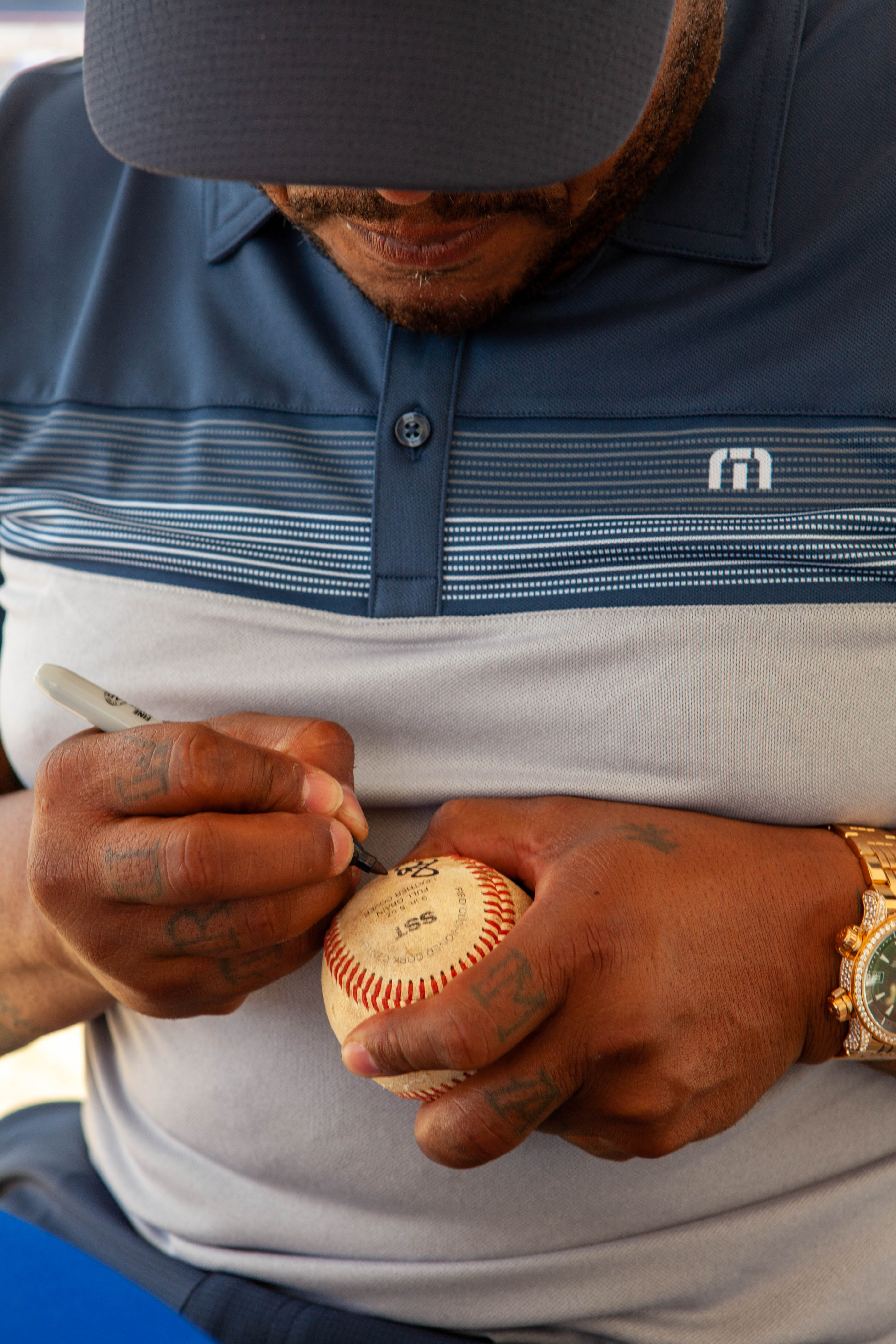 Andruw Jones signs a baseball in close-up view.