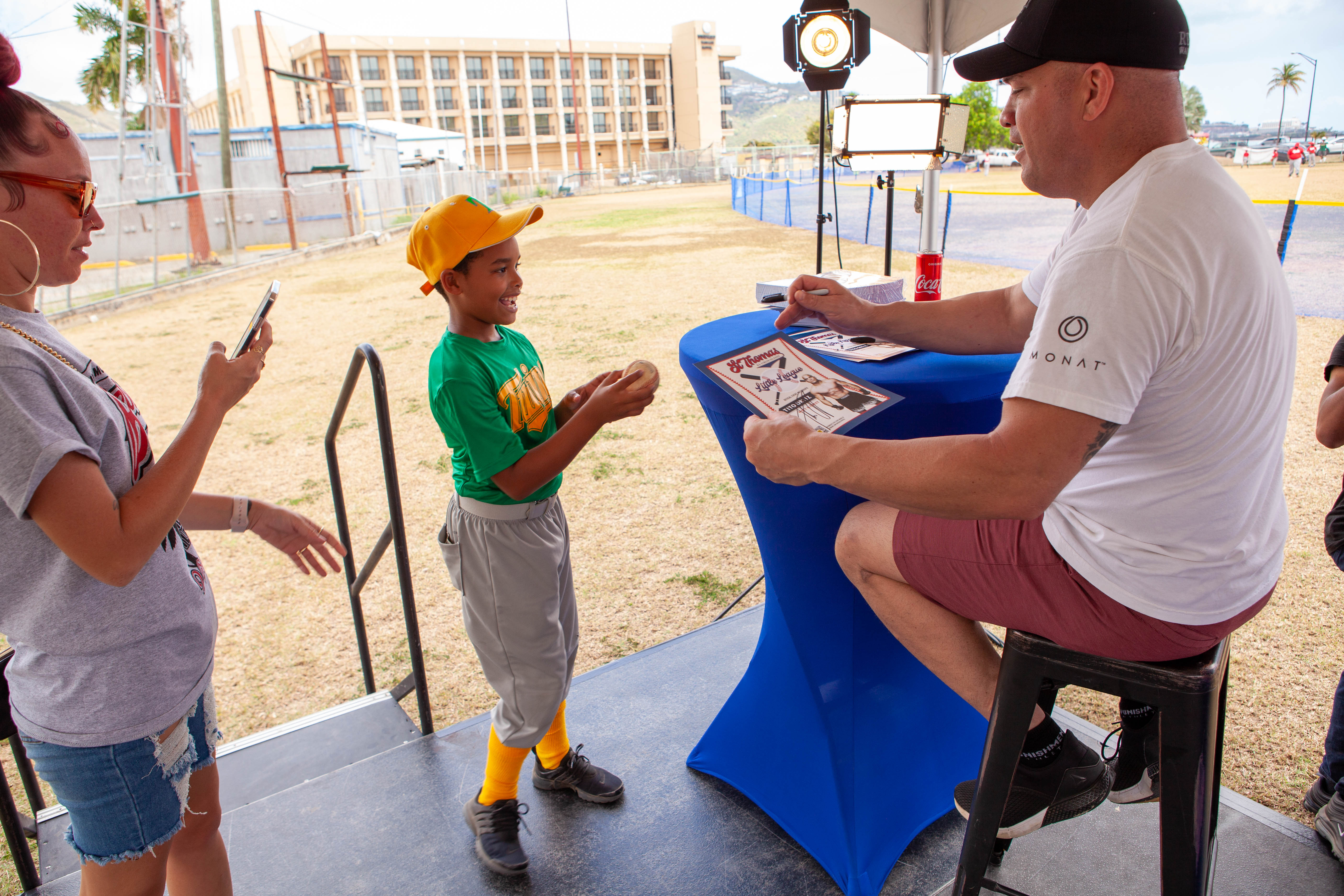 Tito Ortiz signs a blue cap for a young boy.