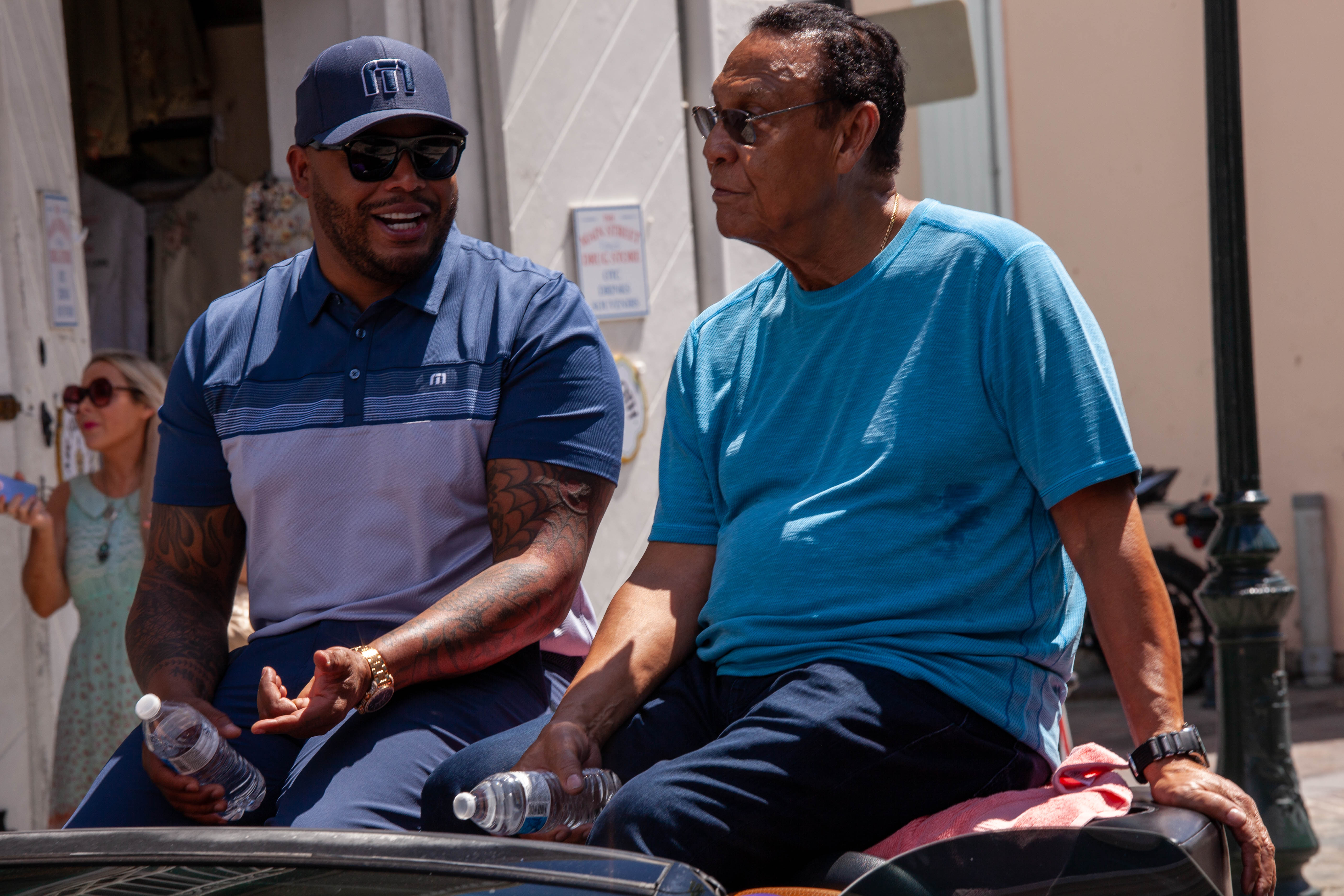 Andruw Jones and Tony Perez smile from a black convertible during the parade.